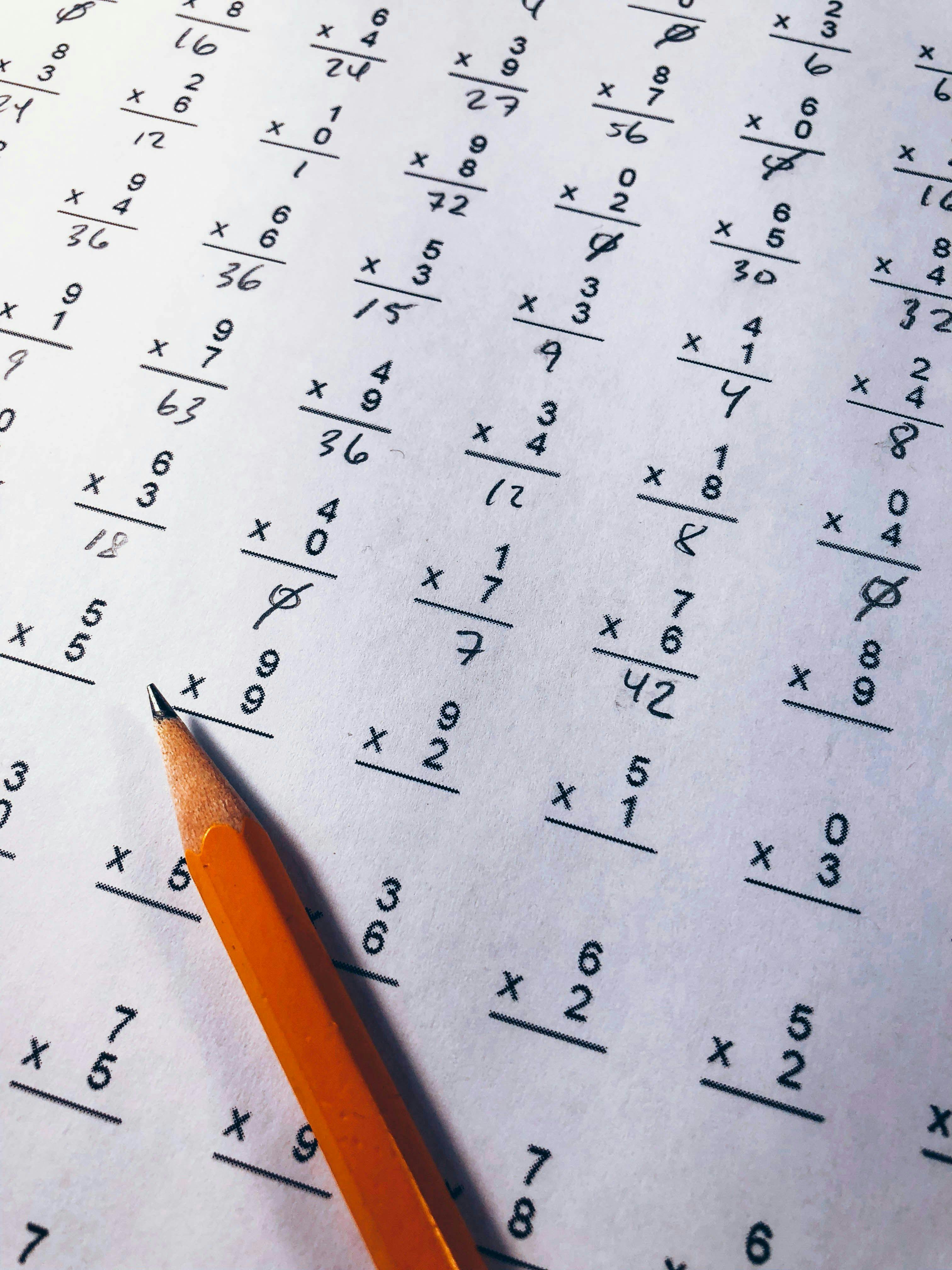 un crayon posé sur une feuille de multiplication