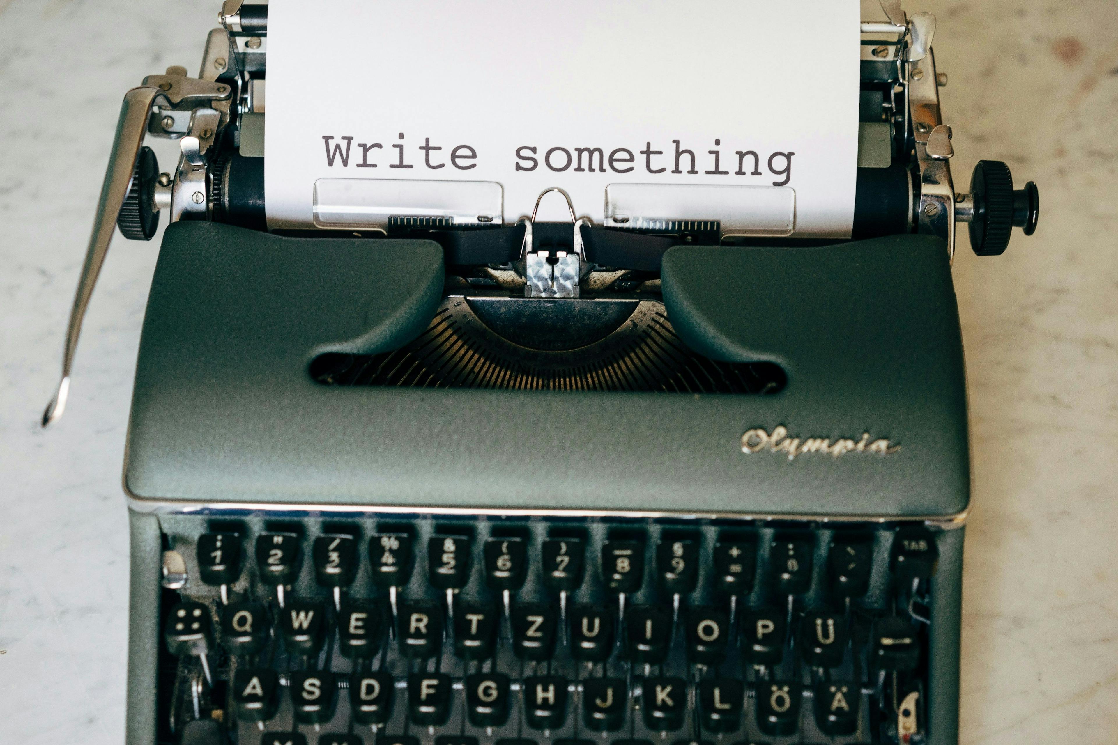 une machine à écrire avec une feuille de papier qui dit écrivez quelque chose