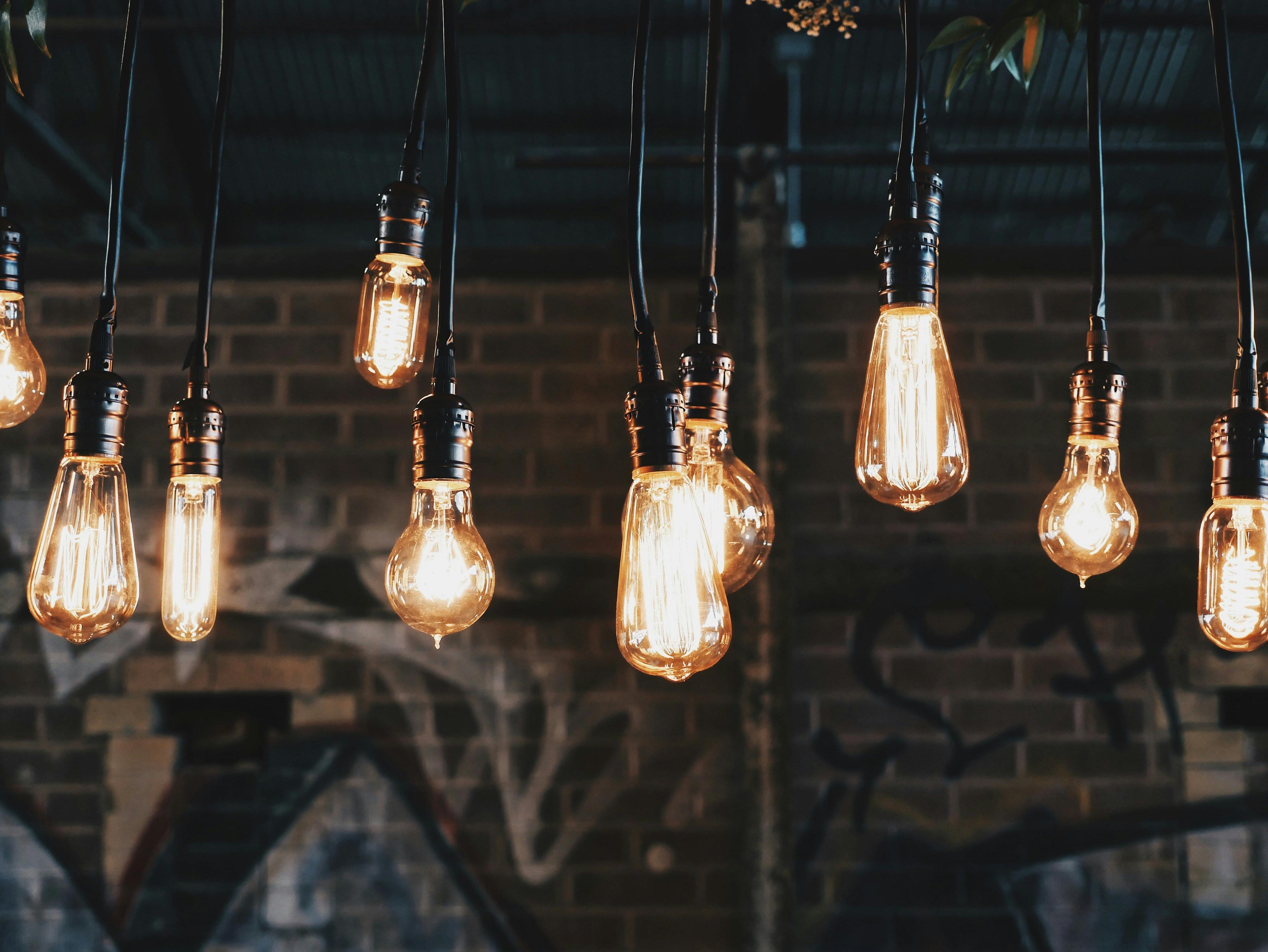 a group of light bulbs hanging from a brick wall