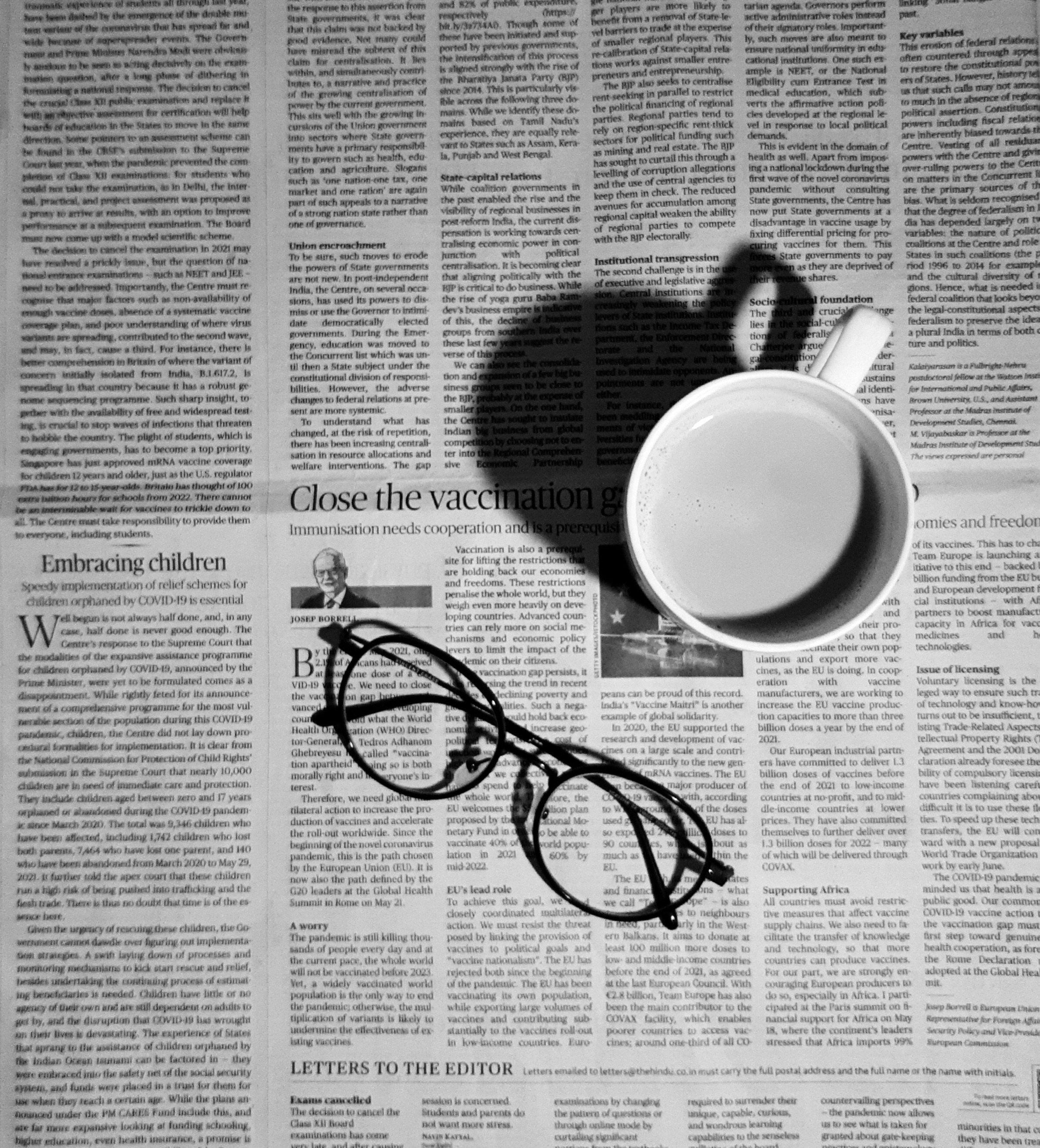 une tasse de café et une paire de lunettes sur un journal