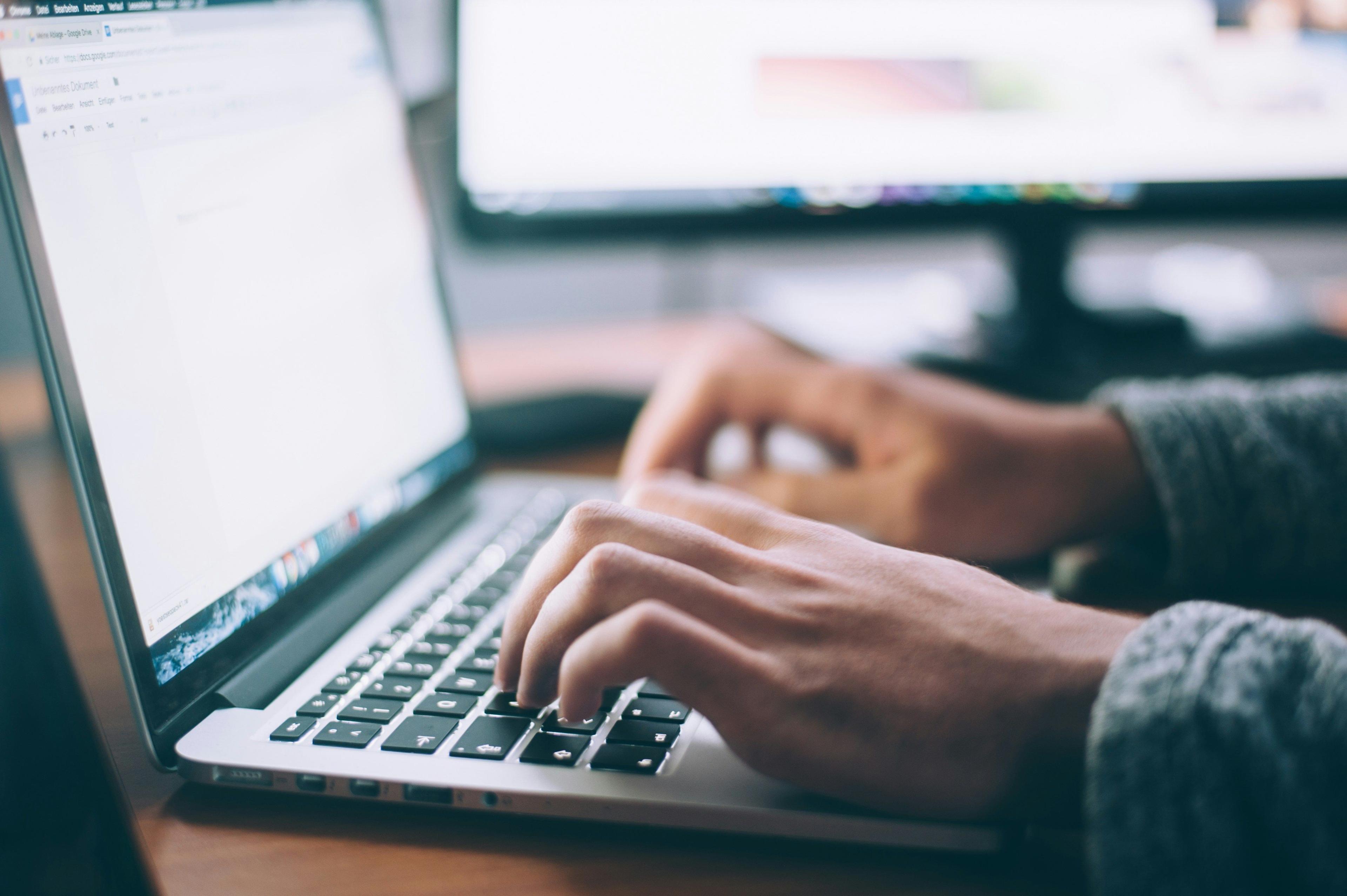 a person writing on a laptop