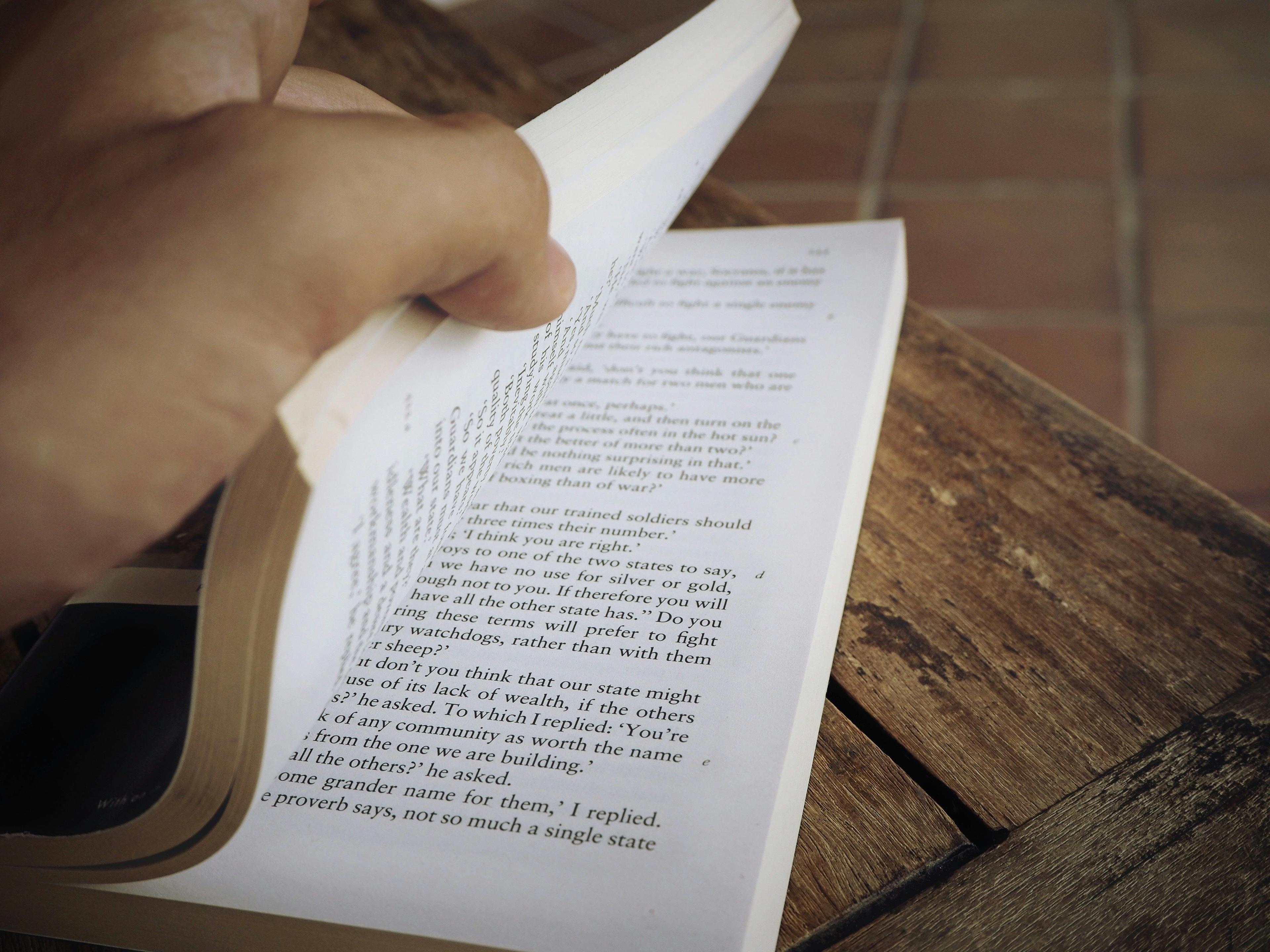 a person is reading a book on a bench