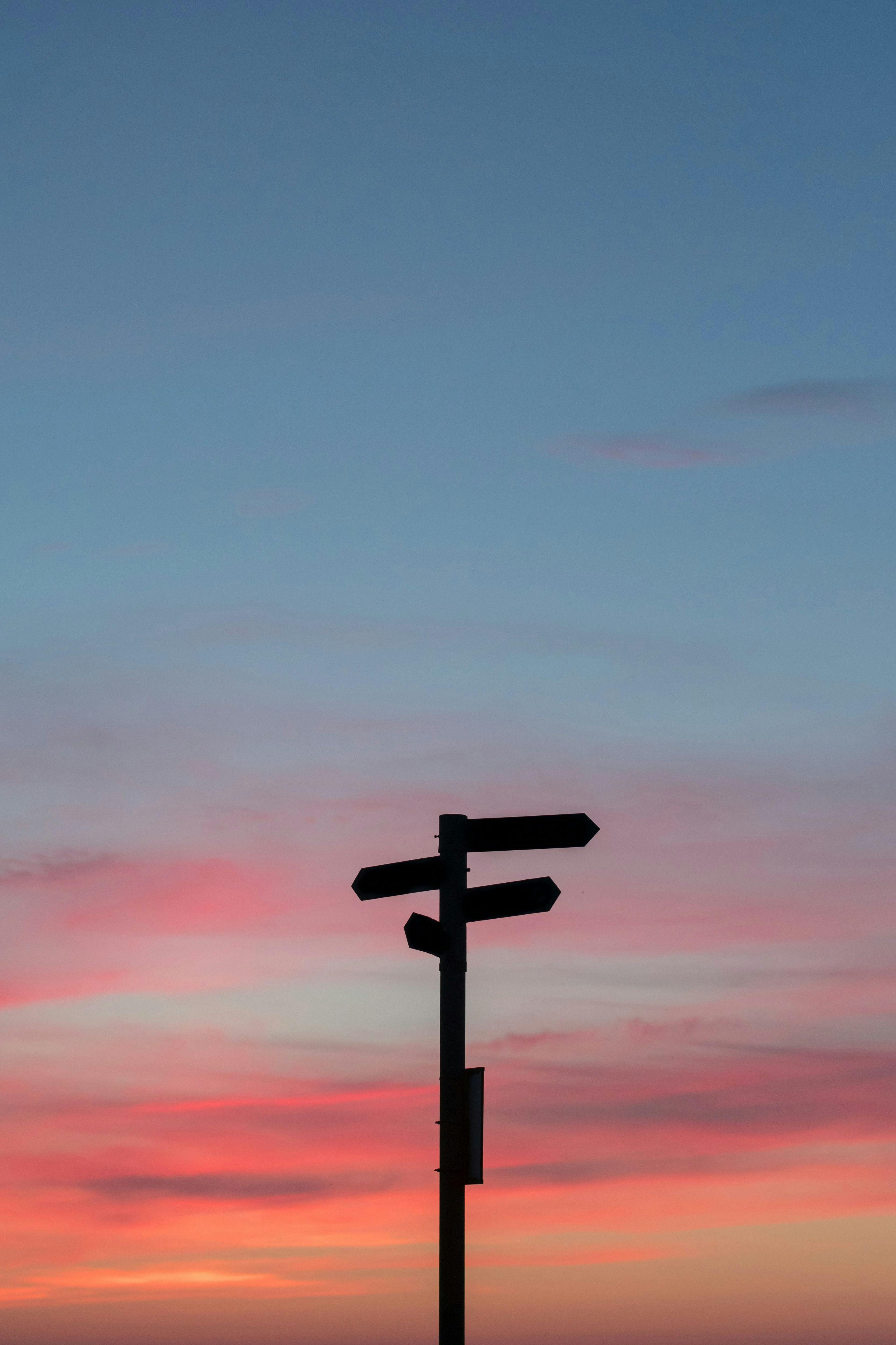 une silhouette dun panneau directionnel au coucher du soleil