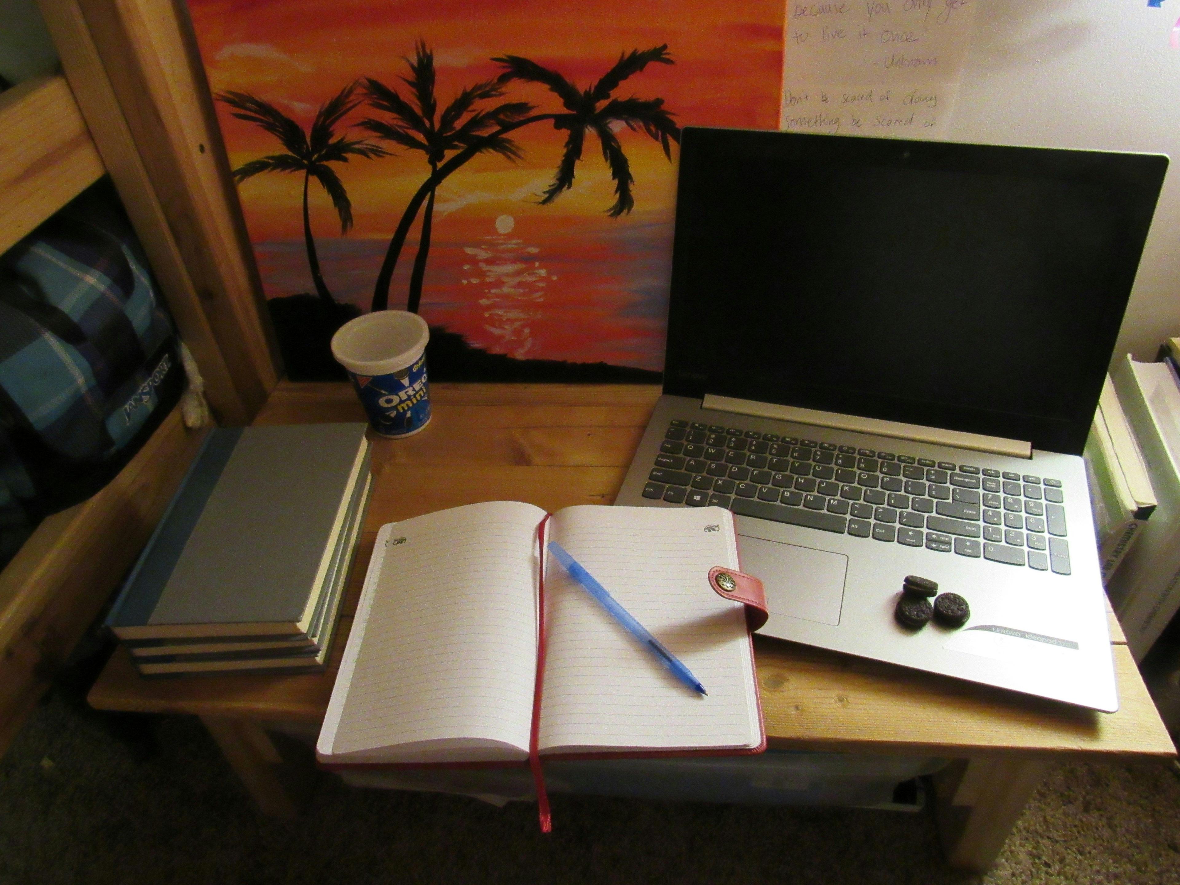 a laptop computer sitting on top of a wooden desk