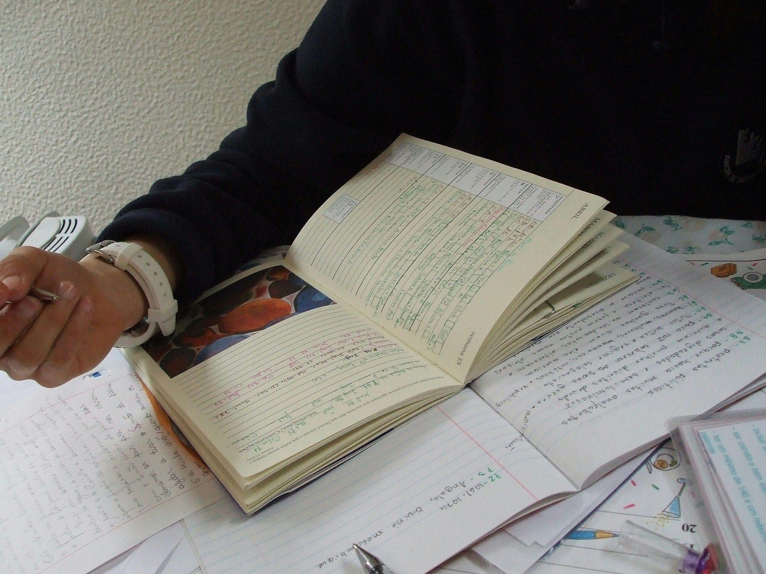 a person sitting at a table with a bunch of papers