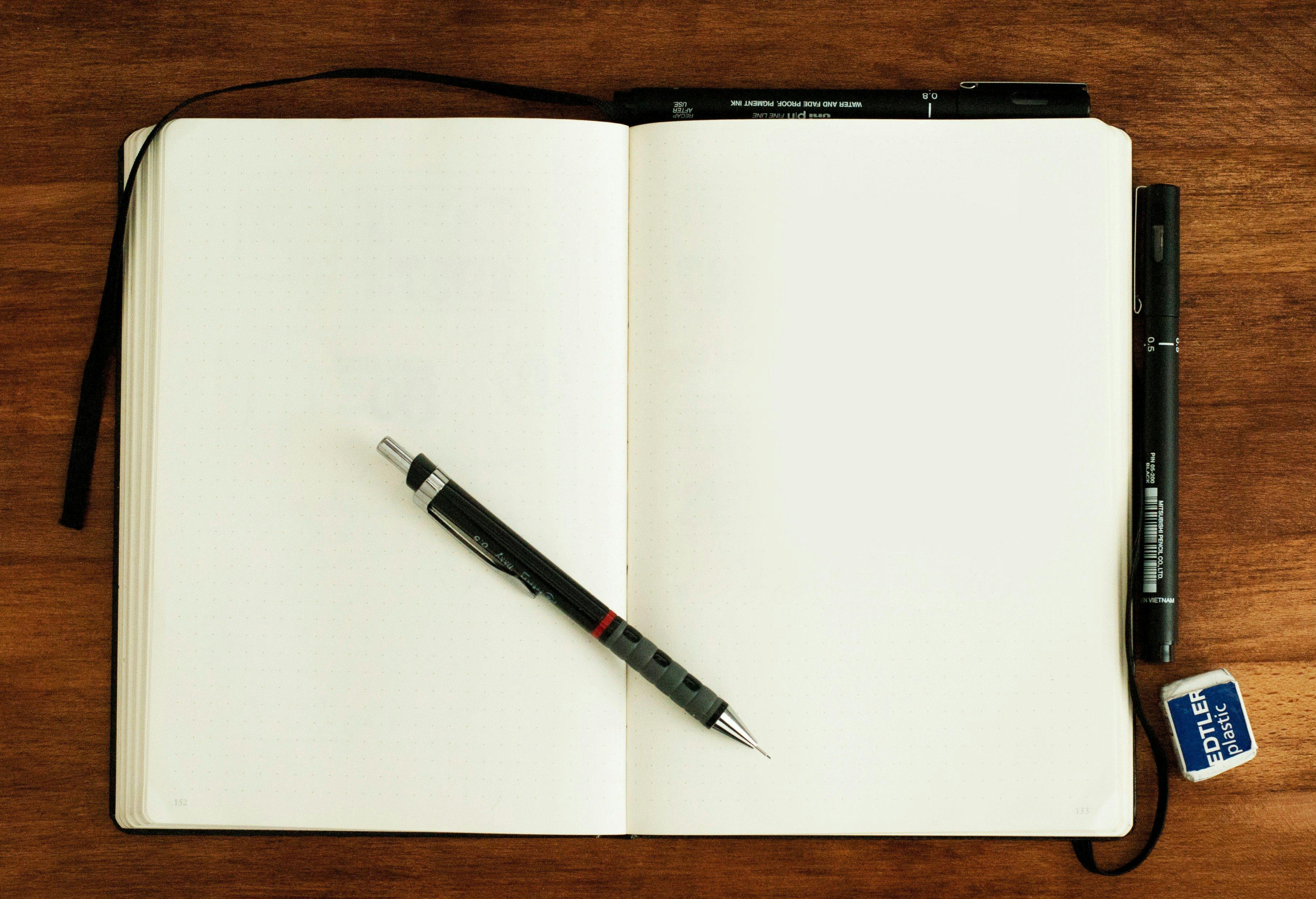 un cahier et un stylo sur une table en bois