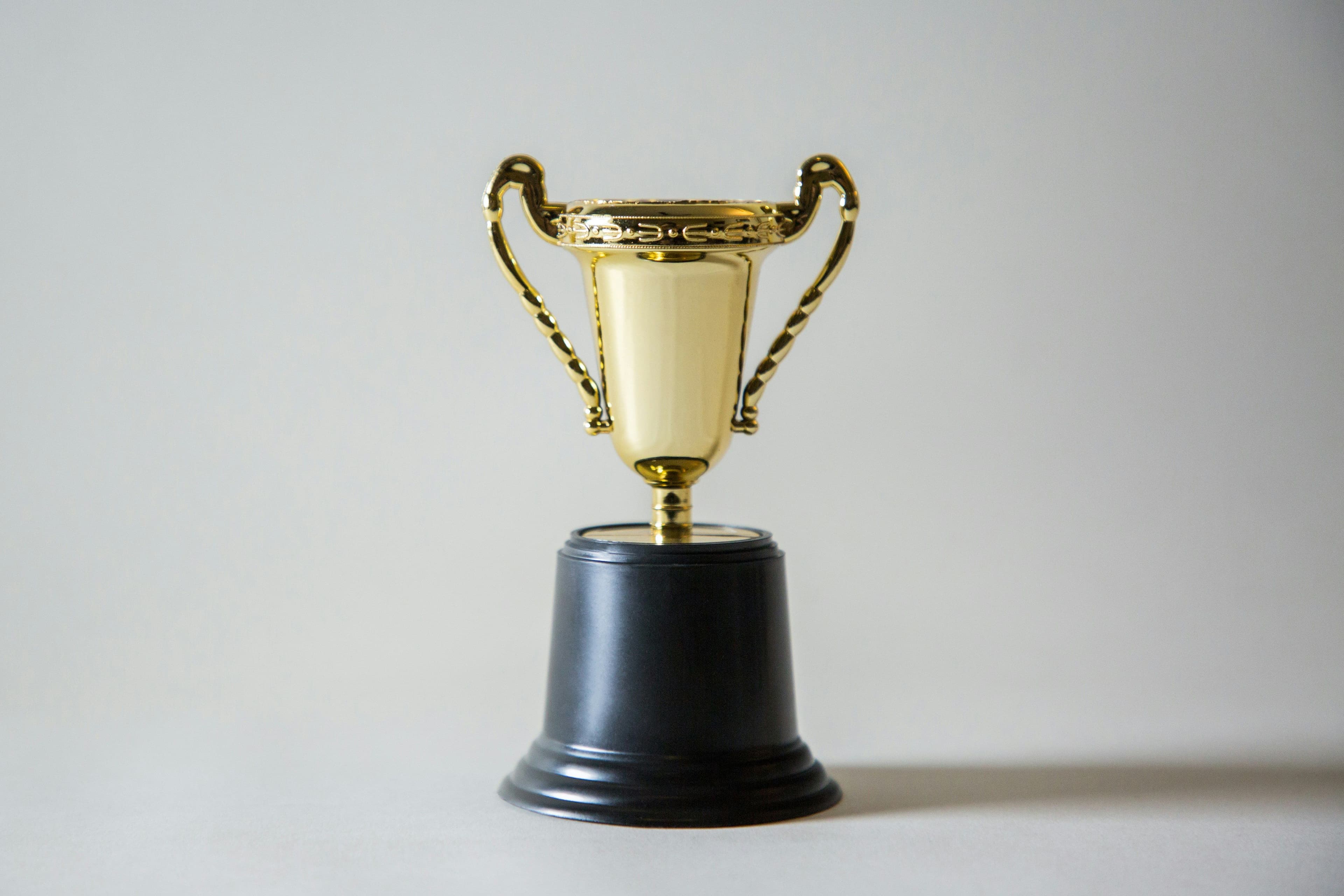 a gold trophy sitting on top of a black pedestal