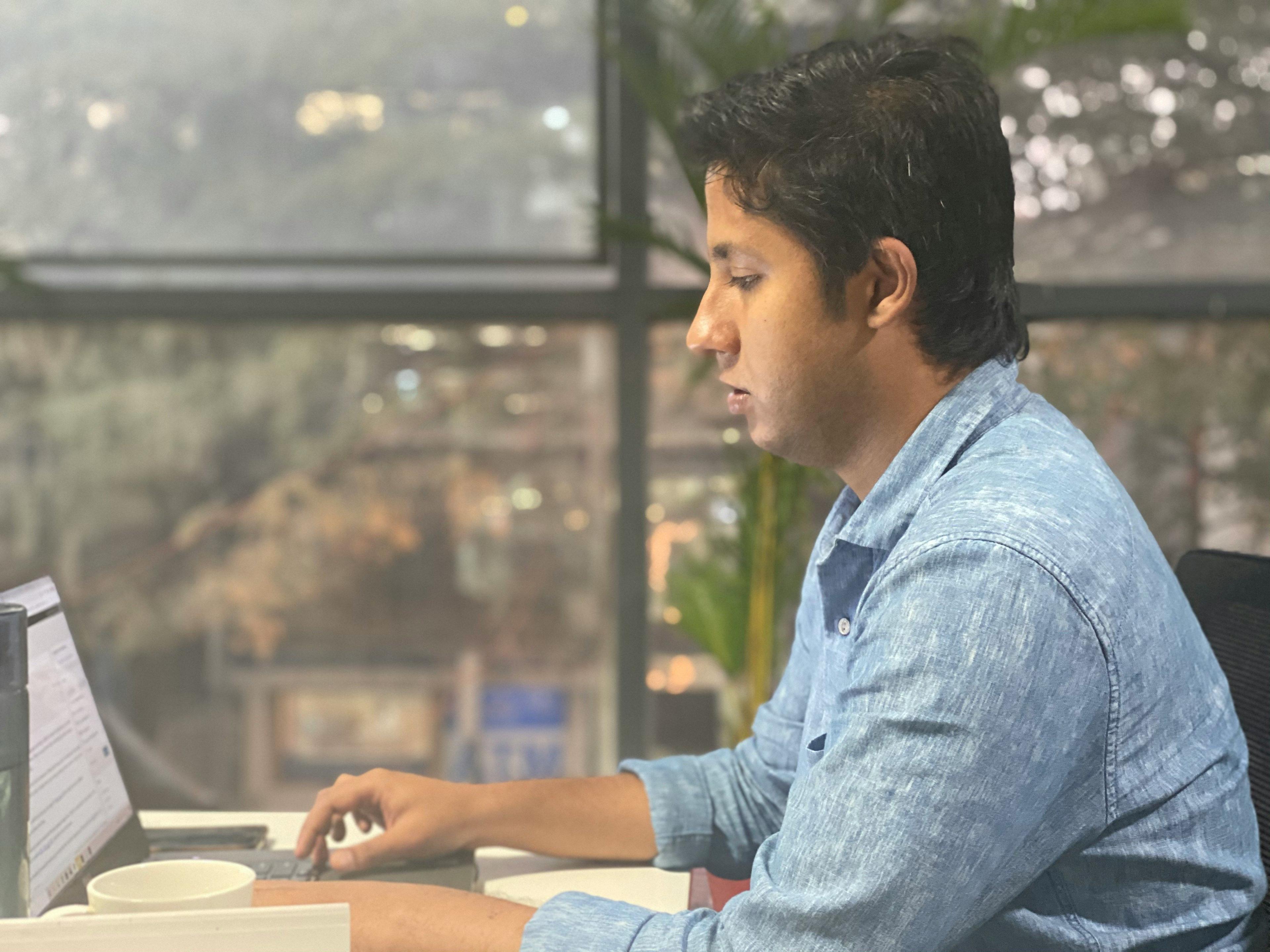 a man sitting at a desk using a laptop computer