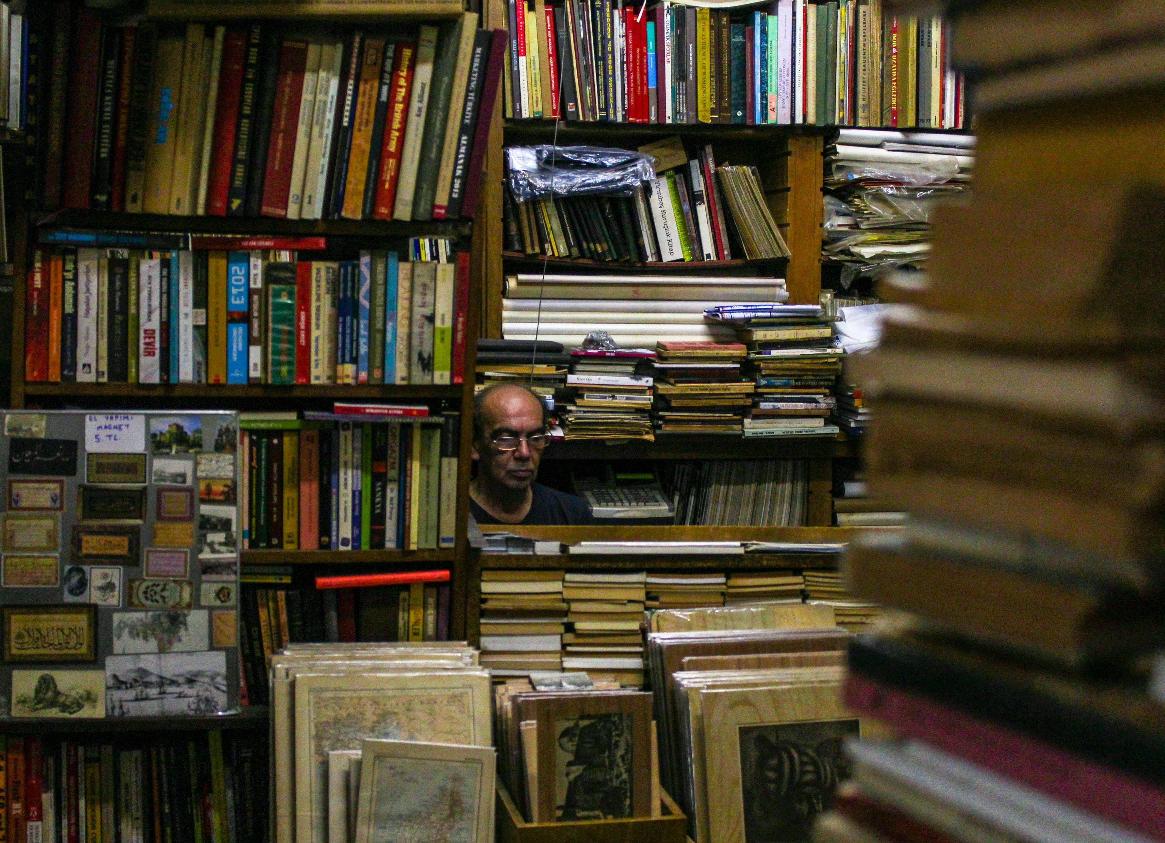 un homme regarde à travers une bibliothèque pleine de livres