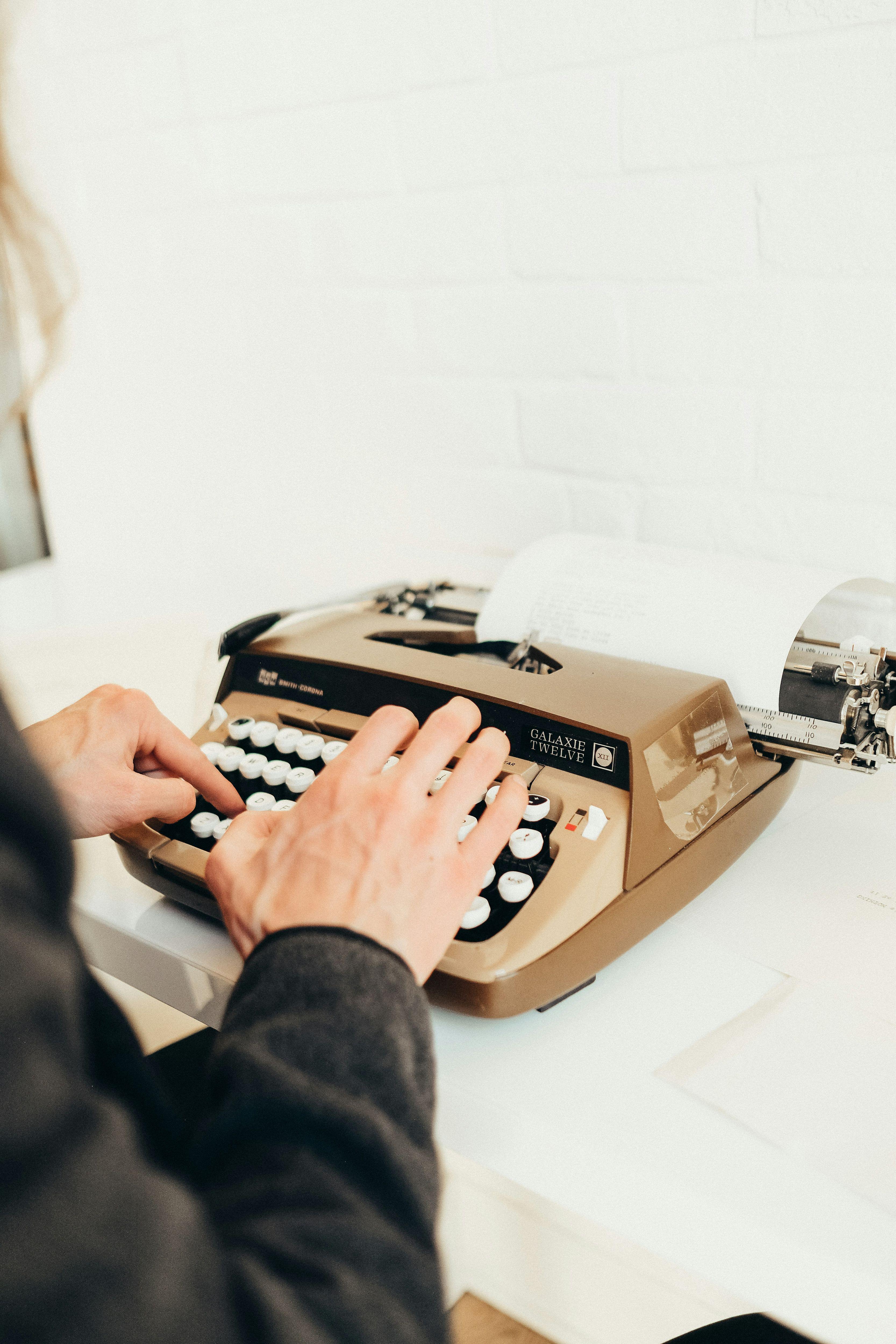 a person typing on a typewriter at a desk