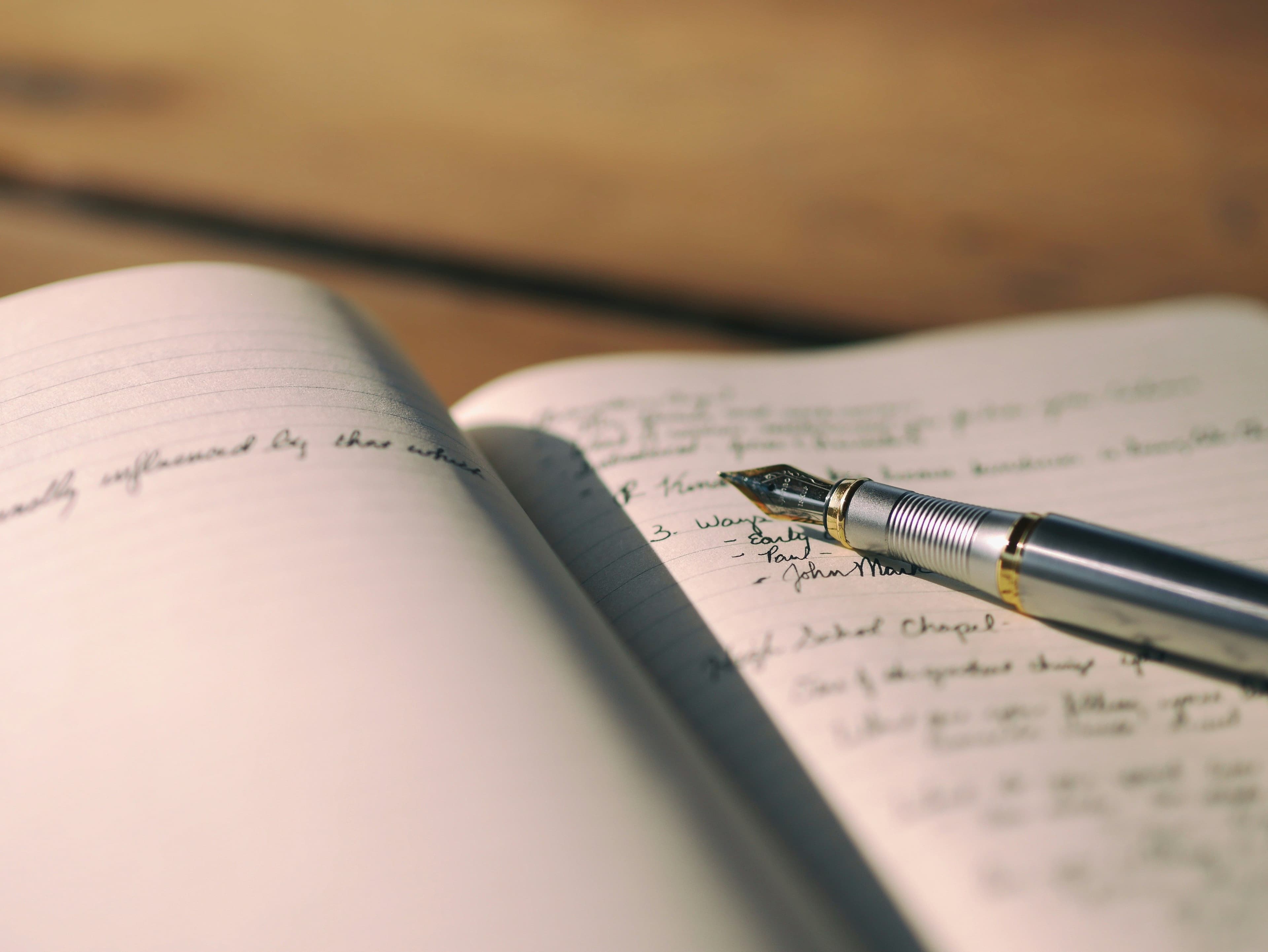 un stylo plume posé sur un carnet ouvert